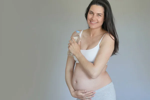 Беременная Женщина Держит Бутылку Воды Изолированная — стоковое фото