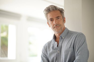 Çağdaş evde kameraya bakan yakışıklı olgun adam Portresi