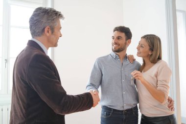 Emlakçı mutlu yeni ev sahiplerine anahtarları teslim