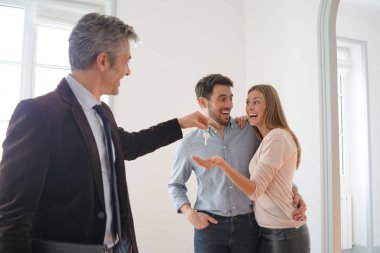 Emlakçı mutlu yeni ev sahiplerine anahtarları teslim