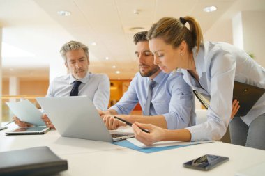 Ofiste bilgisayara bakan bir grup başlangıç iş arkadaşı