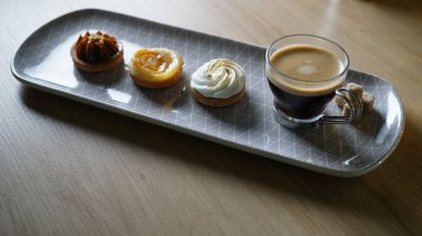 Kahve ve üç lezzetli mini tatlılar hizmet veren uzun tabak