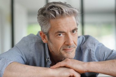 Çağdaş evde kameraya bakan yakışıklı olgun adam Portresi