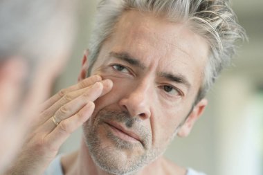 Evde aynaya bakan olgun yakışıklı adam Portresi