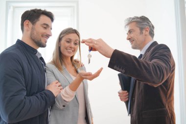 Emlakçı mutlu yeni ev sahiplerine anahtarları teslim