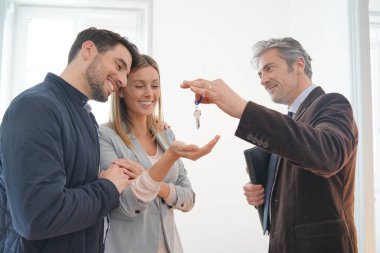 Emlakçı mutlu yeni ev sahiplerine anahtarları teslim