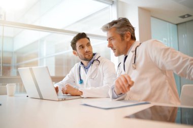 Doktorlar hastanede hastanın sonuçları üzerinden gidiyor