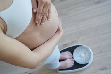 Banyo ölçeğinde duran hamile kadının üst görünümü