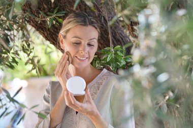 Güzel kadın açık havada makyaj uygulayarak