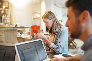 Birlikte çalışma alanında dizüstü bilgisayarlarda iki kişi