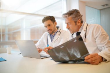 Doktorlar hastanede hastanın sonuçları üzerinden gidiyor