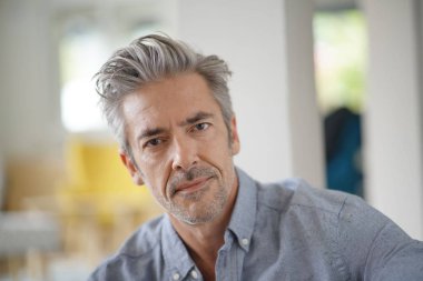 Çağdaş evde kameraya bakan yakışıklı olgun adam Portresi