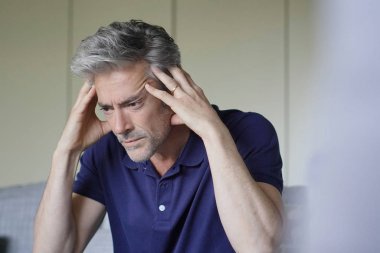 Evde kötü baş ağrısı olan olgun adam