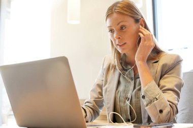 Kulaklık ve bilgisayarla çalışan genç bir profesyonel.