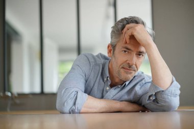 Çağdaş evde kameraya bakan yakışıklı olgun adam Portresi