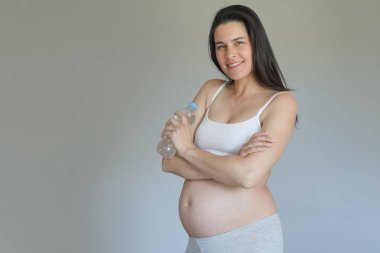 Hamile kadın su şişesi tutan, izole