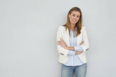 Dinamik iş kadını gri arka planda kameraya bakıyor