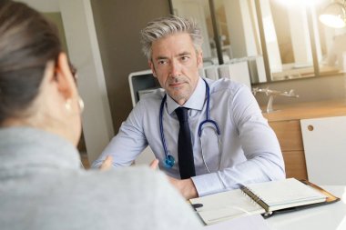 Doktor klinik ofisinde hasta ile sonuçları geçiyor