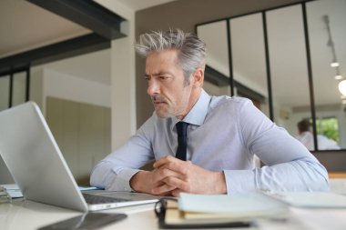 Çağdaş ofiste çalışan yakışıklı işadamı