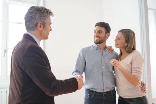 Fastighetsmäklare Lämna Över Nycklar Till Lyckliga Nya Husägare — Stockfoto