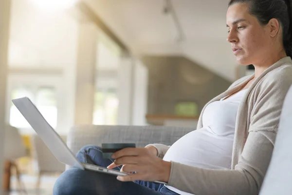 Portrait of pregnant woman relaxing in sofa, shopping online