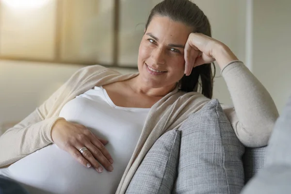 ソファでくつろぐ妊婦の肖像 — ストック写真