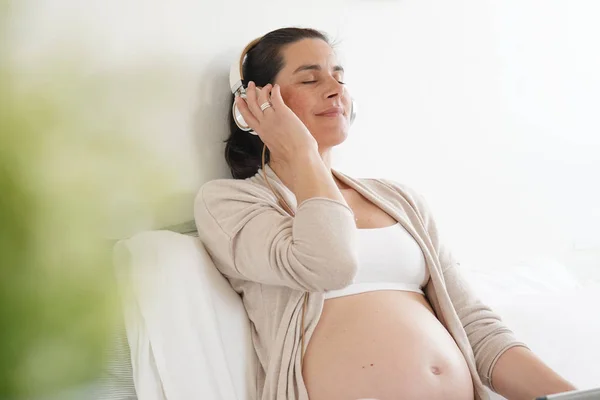 Gravid Kvinna Kopplar Sängen Och Lyssnar Musik — Stockfoto