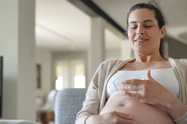 Schwangere Auf Dem Sofa Müsli Vor Dem Fernseher — Stockfoto