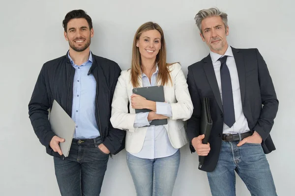 Happy sales team standing together on grey background