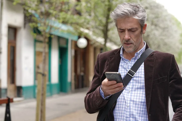 在市中心使用手机的成熟男人 — 图库照片