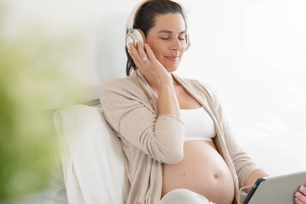 Gravid Kvinna Kopplar Sängen Och Lyssnar Musik — Stockfoto