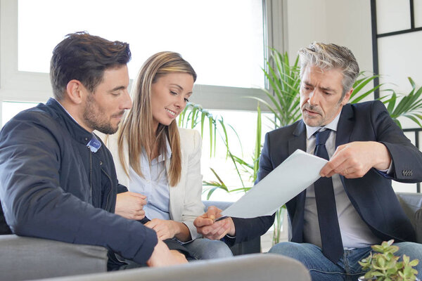 Couple looking over buyers agreement with real estate agent