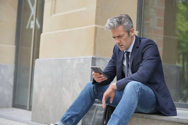 Businessman Sitting Outdoors Looking Stressed — Stock Photo, Image