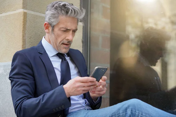 Businessman Sitting Outdoors Looking Stressed — Stock Photo, Image