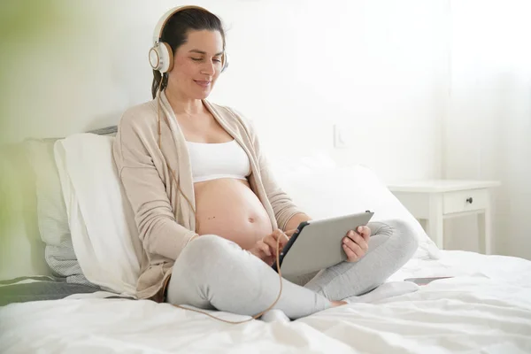 Gravid Kvinna Kopplar Sängen Och Lyssnar Musik — Stockfoto