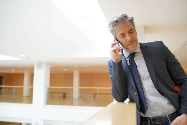 Çağdaş Ofiste Cep Telefonu Ile Olgun Işadamı — Stok fotoğraf