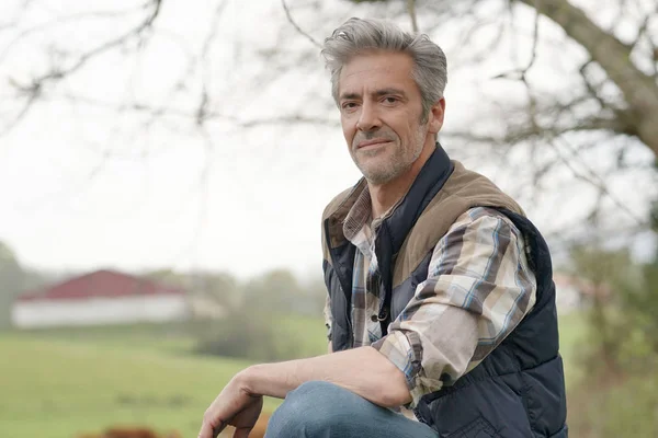 カメラを見てフェンスに寄りかかっている魅力的な農家 — ストック写真