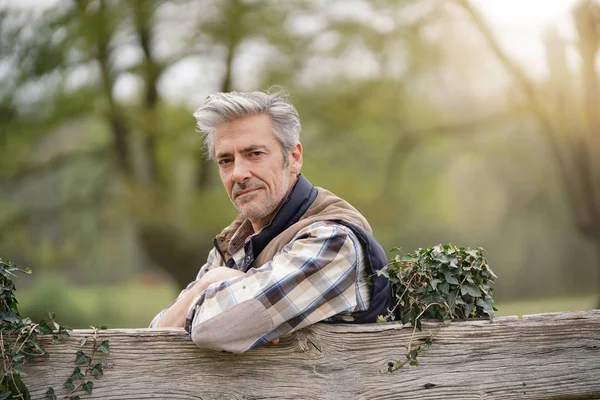 カメラを見てフェンスに寄りかかっている魅力的な農家 — ストック写真