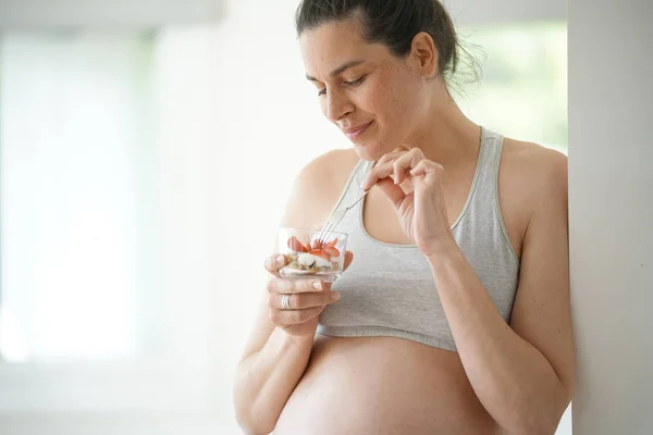 Беременная Женщина Опирается Стену Ест Клубнику — стоковое фото
