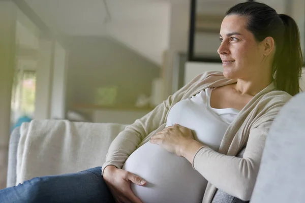 ソファでくつろぐ妊婦の肖像 — ストック写真