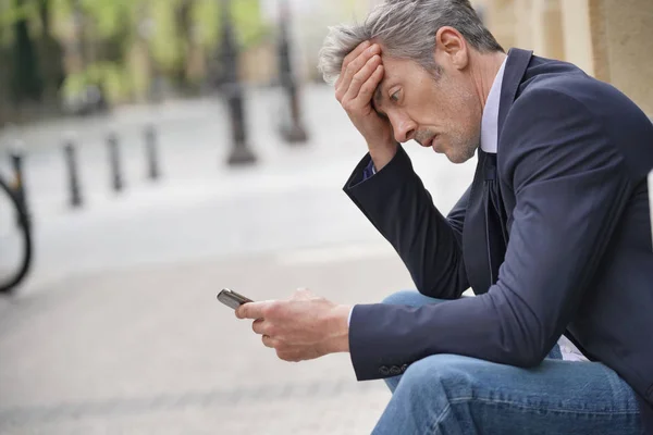 Businessman Sitting Outdoors Looking Stressed — Stock Photo, Image