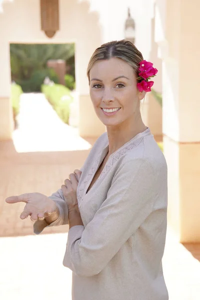 Natural beauty with flower in hair standing in Moroccan villa