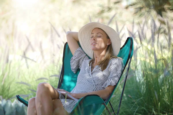 美丽的女人在乡村的草坪椅上休息 — 图库照片