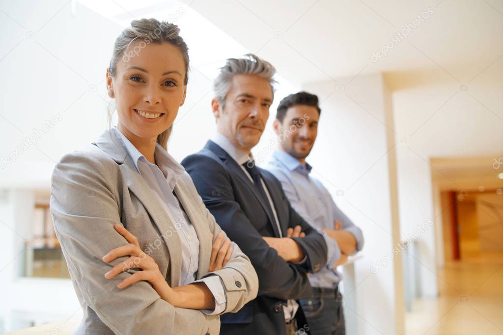 Mixed business team standing in office looking at camera