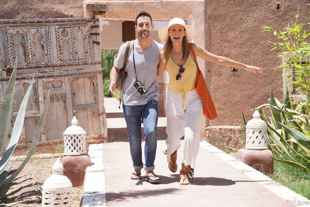 Cheerful couple exploring traditional Moroccan villa and gardens