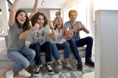 Bir grup arkadaş TV 'de maç izlerken neşeleniyor
