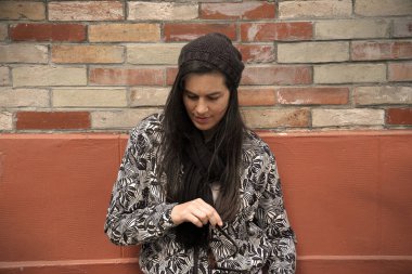 Tuğla duvarda dikilen modaya uyan kadın