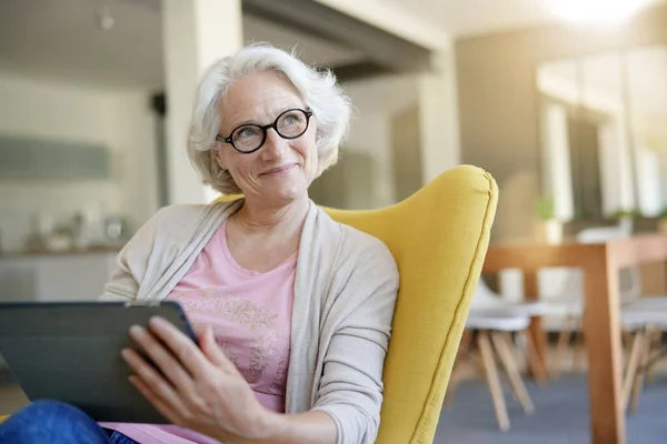 Senior Kvinna Avkopplande Fåtölj Och Använda Digitala Surfplatta — Stockfoto