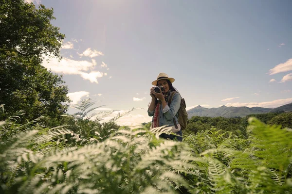 美しい自然の風景の中で写真を撮る帽子を持つ女性 — ストック写真