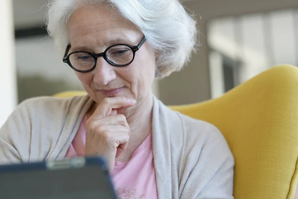 Senior Kvinna Avkopplande Fåtölj Och Använda Digitala Surfplatta — Stockfoto